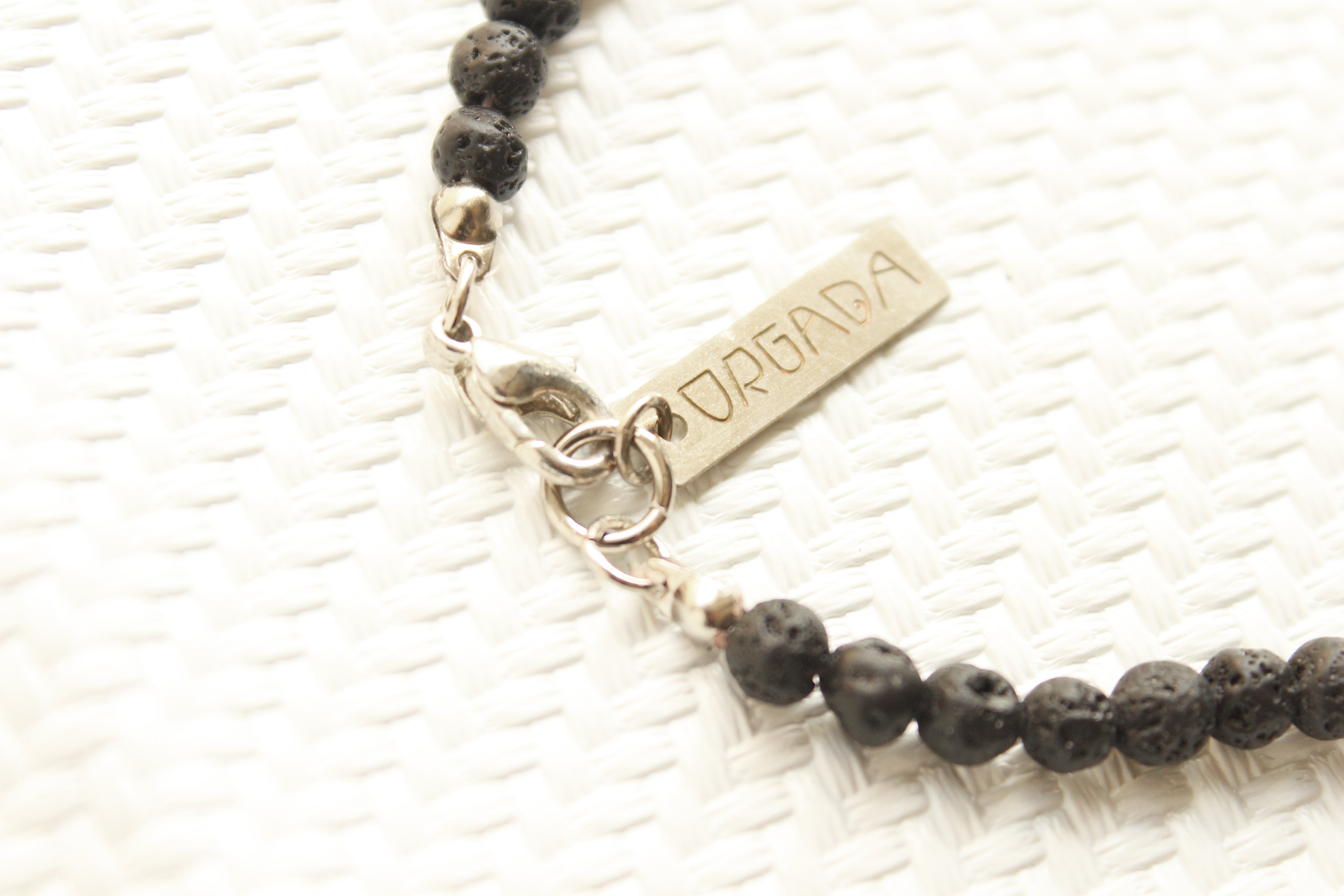 ORGADA necklace made of black lava beads and a lobster clasp closure photographed in close-up