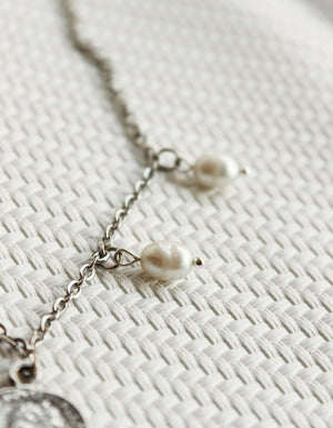 ORGADA's White Wisdom necklace hung and photographed on a white background in close-up of the fresh water pearls